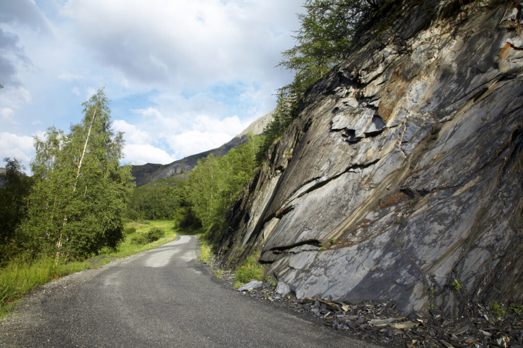 France, Rhône-Alpes, The Ecrins National Park. Lane running past a natural wall of Slate, within the Ecrins National Park near La Grave