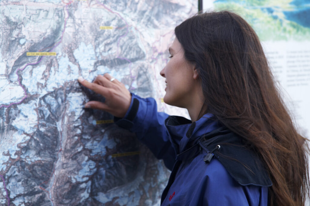 France, Rhône-Alpes, The Ecrins National Park. Female hiker examining a map of the Ecrins National Park near La Grave.