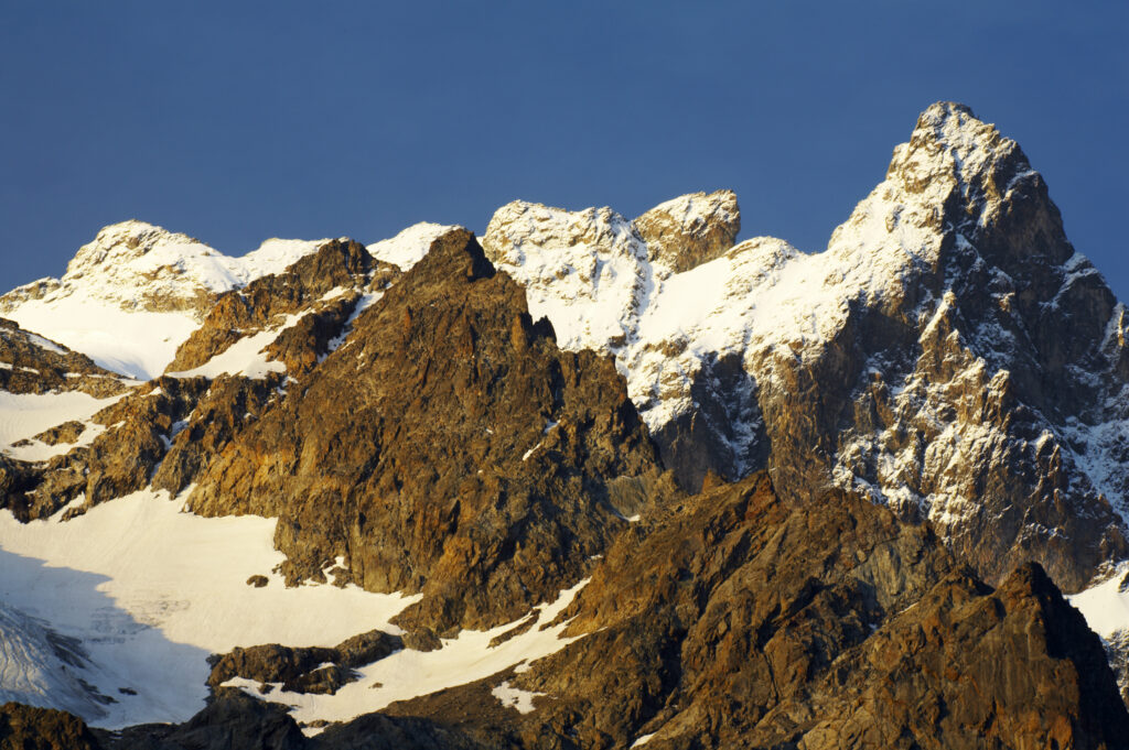 France, Rhône-Alpes, The Ecrins National Park. Morning light illuminates the peak of La Meije after a summer snowfall, within the Ecrins National Park near the village of La Grave