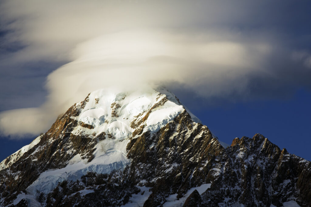 New Zealand, Canterbury, Mt Cook National Park. Storm clouds hug the peak of the mighty Mt Cook (known to the Maori as Aoraki) the highest peak in Australasia at 3755M.