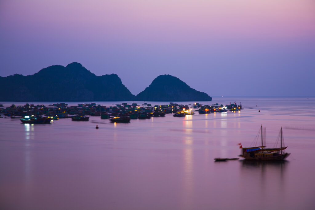 Vietnam, Northern Vietnam, Halong Bay. The pink sunset afterglow at dusk over Cat Ba harbour on Cat Ba Island.