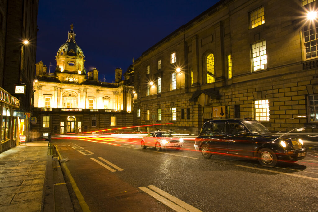 Scotland, Edinburgh, Old Town. A city taxi waiting in traffic on Bank Street. The building at the end of the street is the Bank of Scotland.