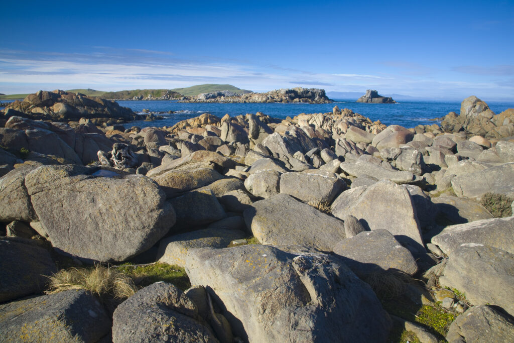 New Zealand, Southland, Cosy Nook. Cosy Nook, a picturesque craggy cove that shelters several fishing boats & holiday cribs.