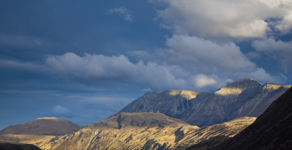 New Zealand, Canterbury, Arthur's Pass National Park. Late afternoon light on the peaks of the national park surrounding the Waimakariri River flats.