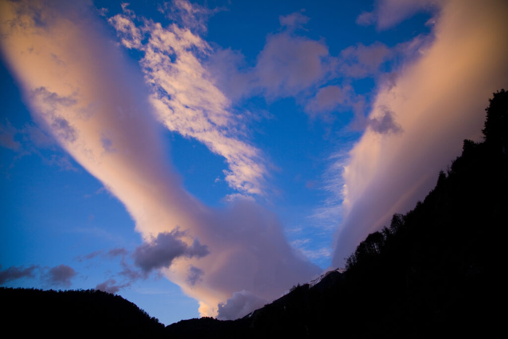New Zealand, Canterbury, Arthur's Pass National Park. Clouds at sunset above the peaks and forests of the park.