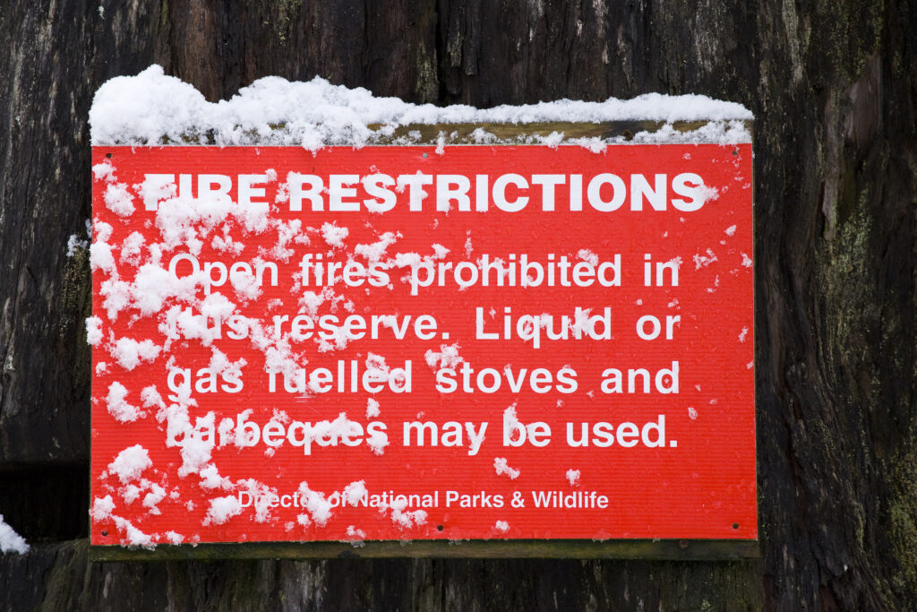 Australia, Tasmania, Cradle Mt - Lake St Clair National Park. Fire restrictions sign at a campsite within the National Park.