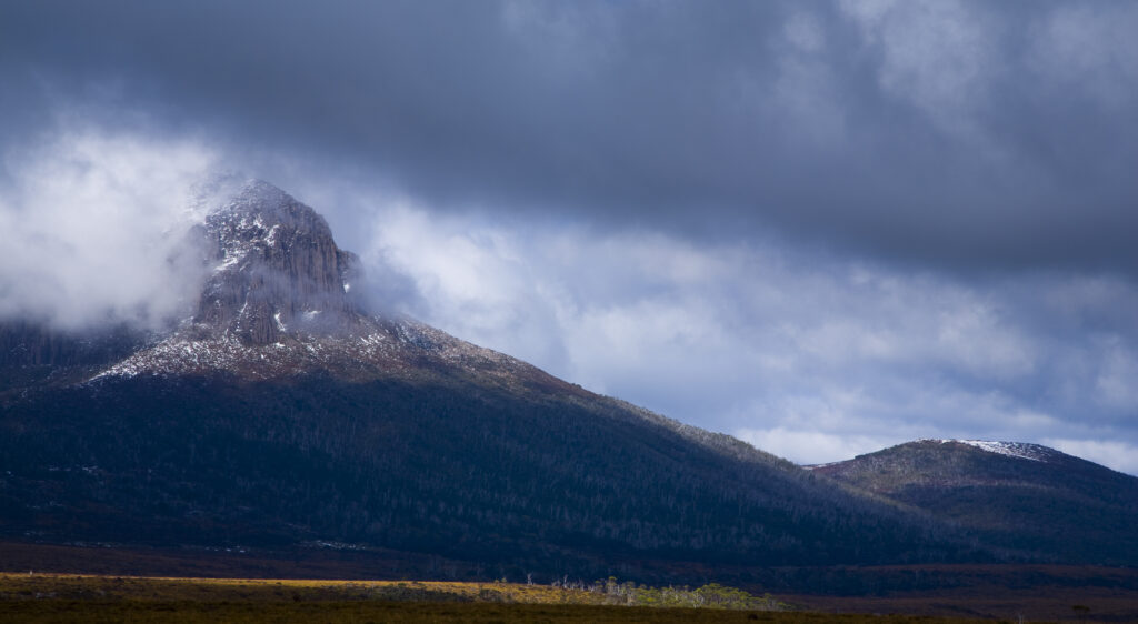 Australia, Tasmania, Cradle Mt - Lake St Clair National Park. Dramatic storm clouds clear revealing Mount Pelion West - Viewed from the Overland Track.