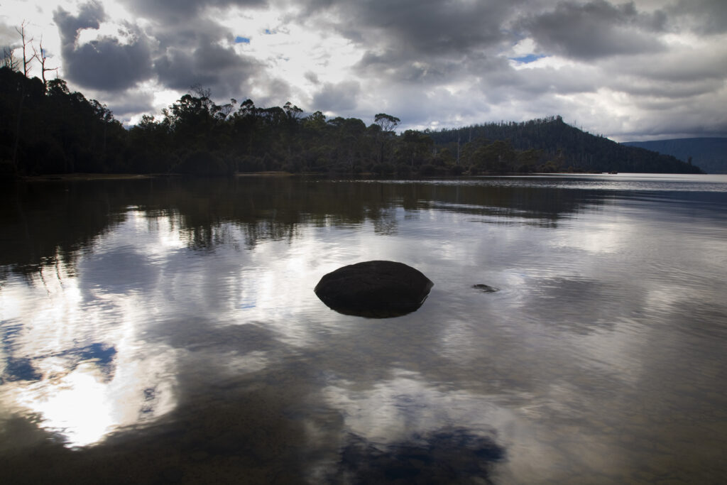 Australia, Tasmania, Cradle Mt - Lake St Clair National Park. Winter storm clouds reflected in the still waters of Lake St Clair.