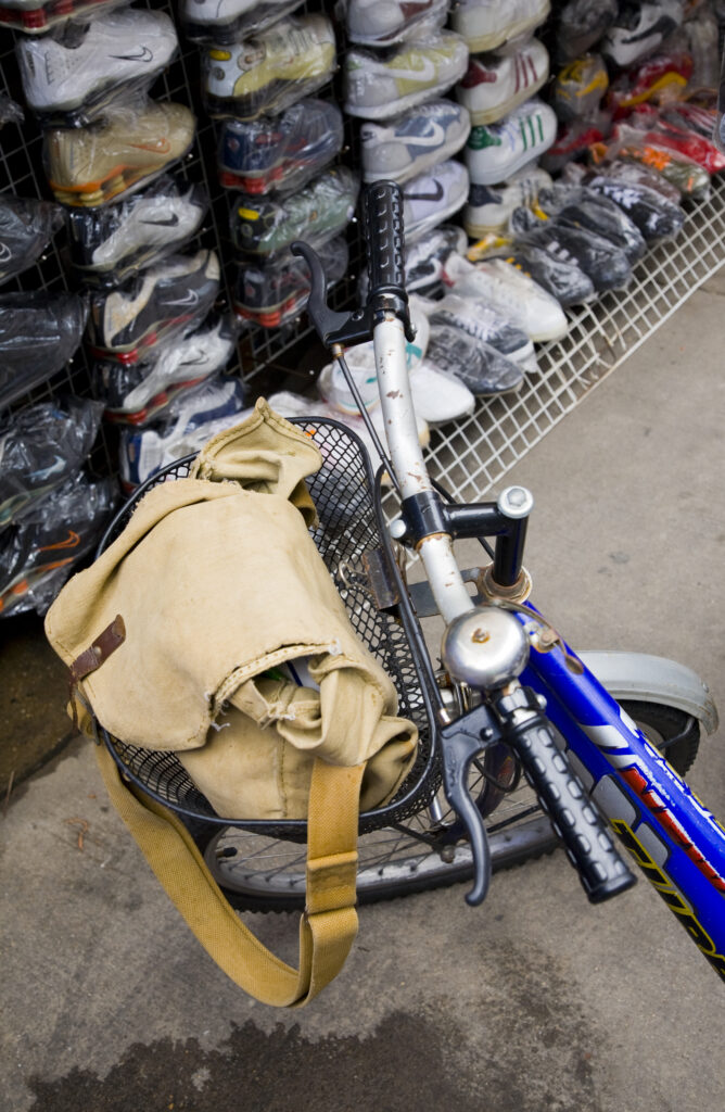 Bicycle outside a market stall selling counterfeit shoes and trainers, located in the infamous Khao San Road.