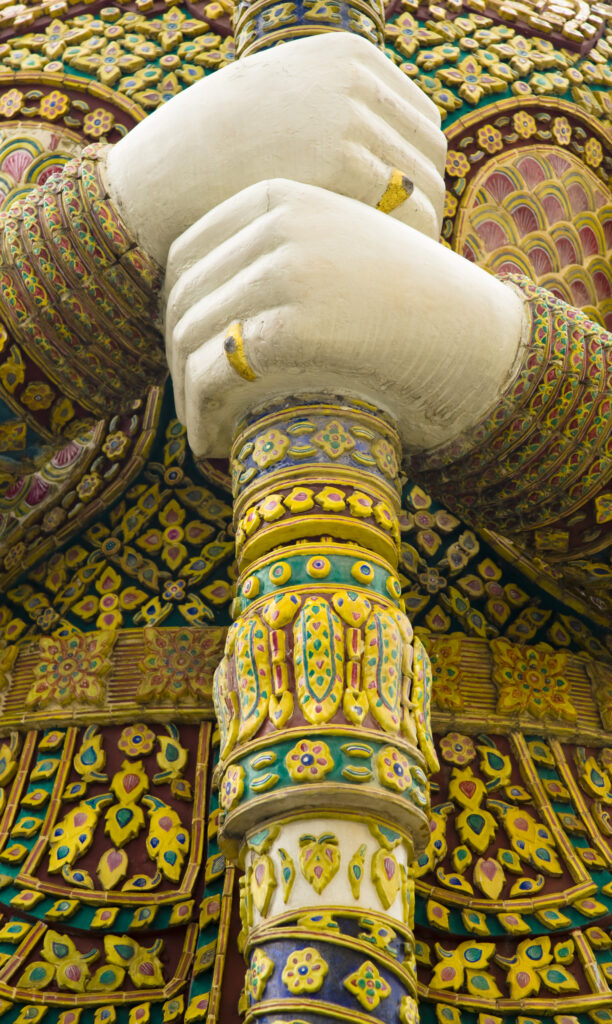 Thailand, Bangkok, The Grand Palace. Statue in the ornate setting of the golden grand palace.