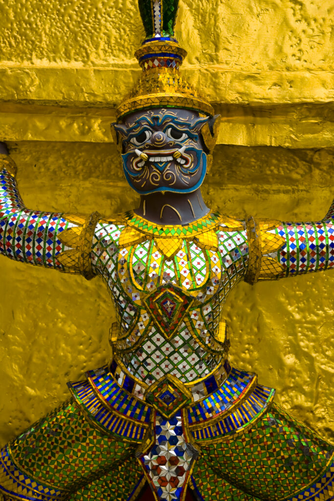 Thailand, Bangkok, The Grand Palace. Statue in the ornate setting of the golden grand palace.