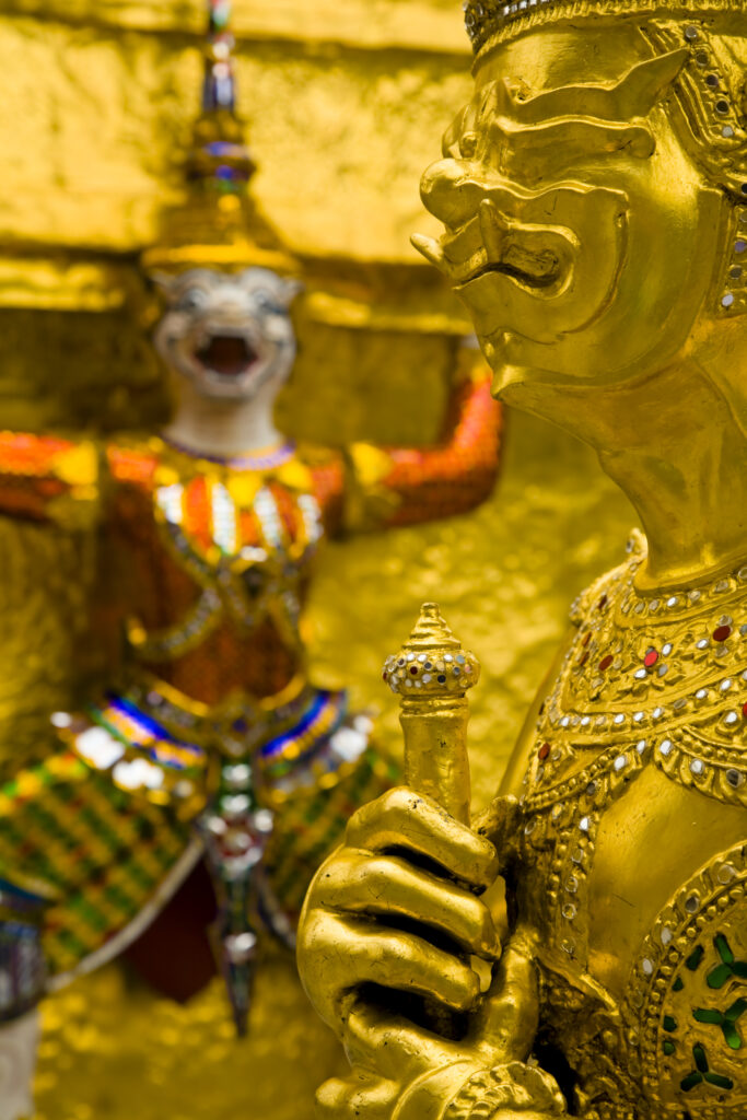 Thailand, Bangkok, The Grand Palace. Statue in the ornate setting of the golden grand palace.