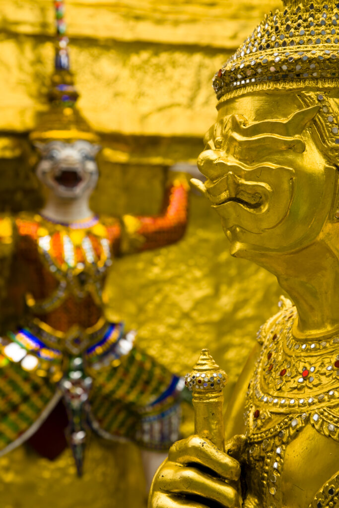 Thailand, Bangkok, The Grand Palace. Statue in the ornate setting of the golden grand palace.