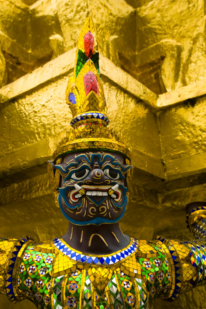 Thailand, Bangkok, The Grand Palace. Statue in the ornate setting of the golden grand palace.