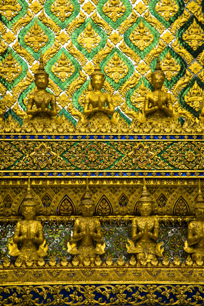 Thailand, Bangkok, The Grand Palace. Statue in the ornate setting of the golden grand palace.