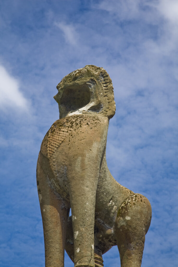 Cambodia, Angkor, Angkor Wat. Statue alongside the dramatic remains of Angkor Wat.