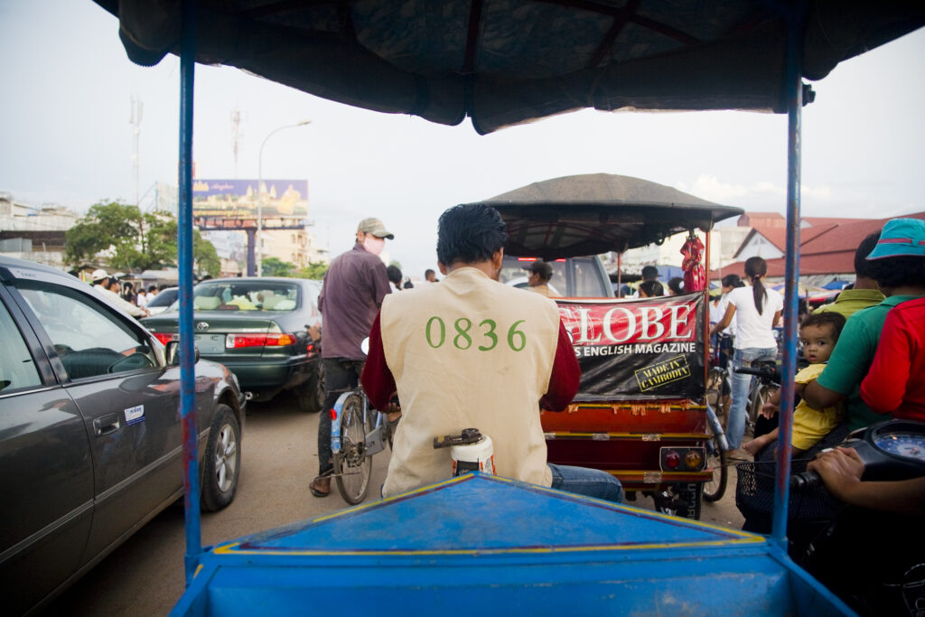 Cambodia, Siem Reap. Tut tut driver on a congested road in downtown Siem Reap near Angkor.