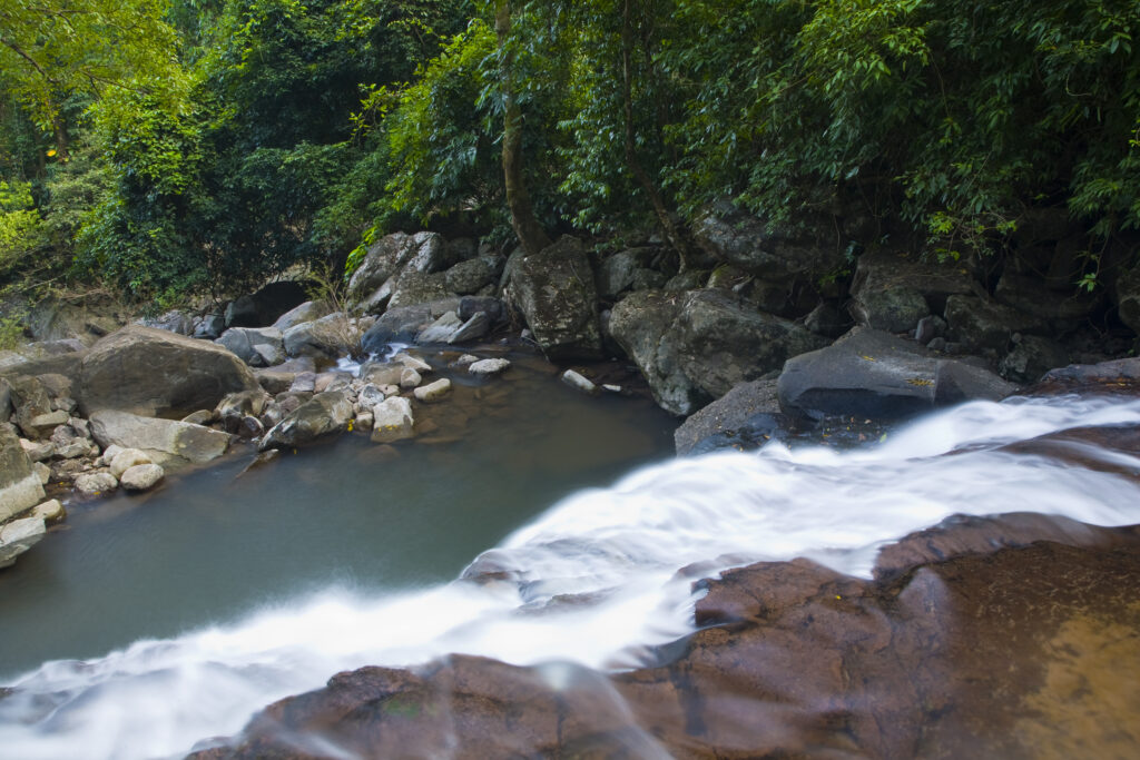 Laos, Ban Na Hin, Waterfall. Downstream of a waterfall as it cascades through native jungle and bush.