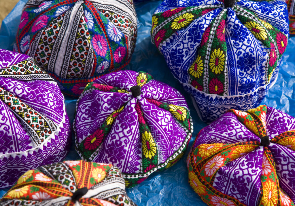 Vietnam, Northern Vietnam, Sapa. Hats on sale via a market stall set up on the roadside of the square.