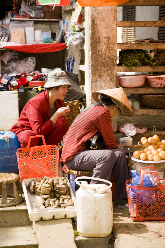 Vietnam, Northern Vietnam, Sapa. Vietnamese women selling local produce at a food market in Sapa.