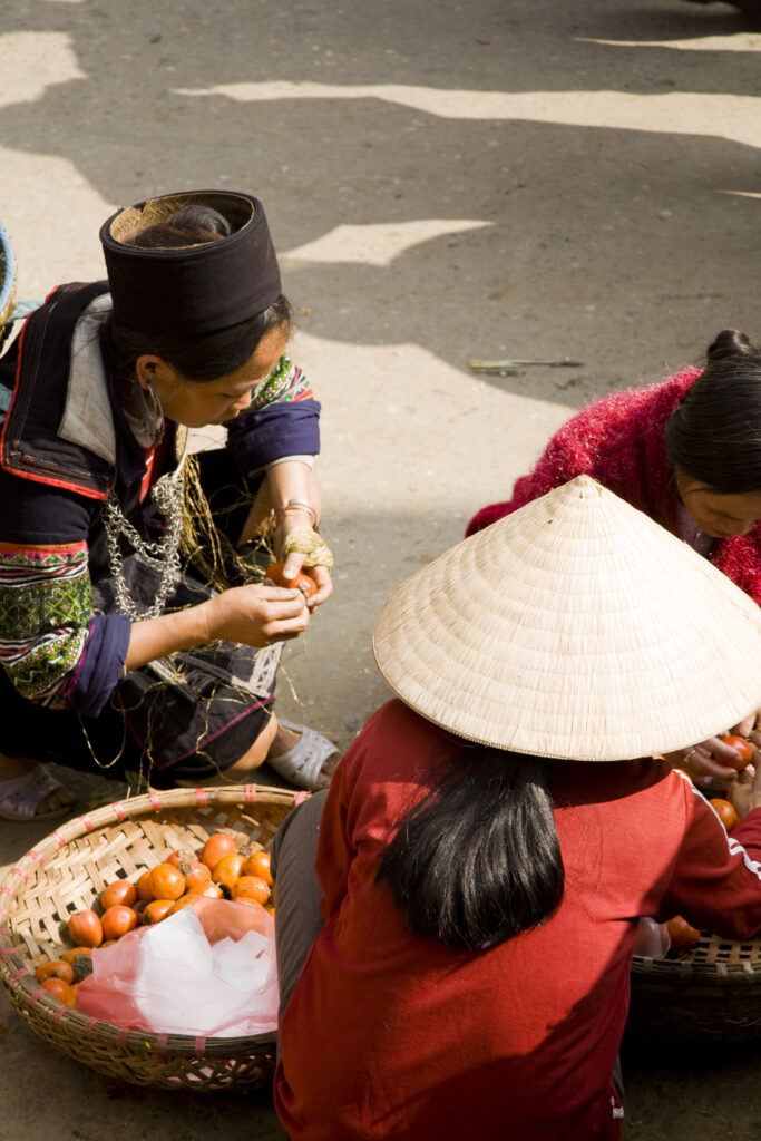 Vietnam, Northern Vietnam, Sapa. Vietnamese women selling local produce at a food market in Sapa.