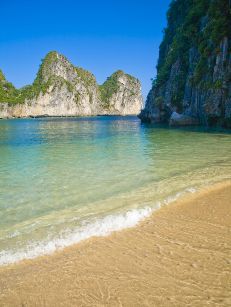 Vietnam, Northern Vietnam, Halong Bay. Sandy coastline amid a group of islands in Halong Bay near Cat Ba Island.
