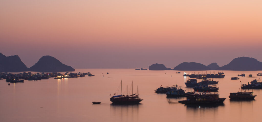 Vietnam, Northern Vietnam, Halong Bay. The pink sunset afterglow at dusk over Cat Ba harbour on Cat Ba Island.