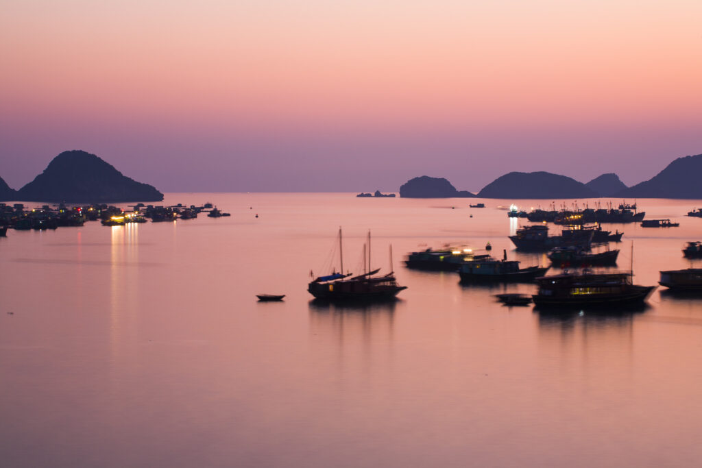 Vietnam, Northern Vietnam, Halong Bay. The pink sunset afterglow at dusk over Cat Ba harbour on Cat Ba Island.
