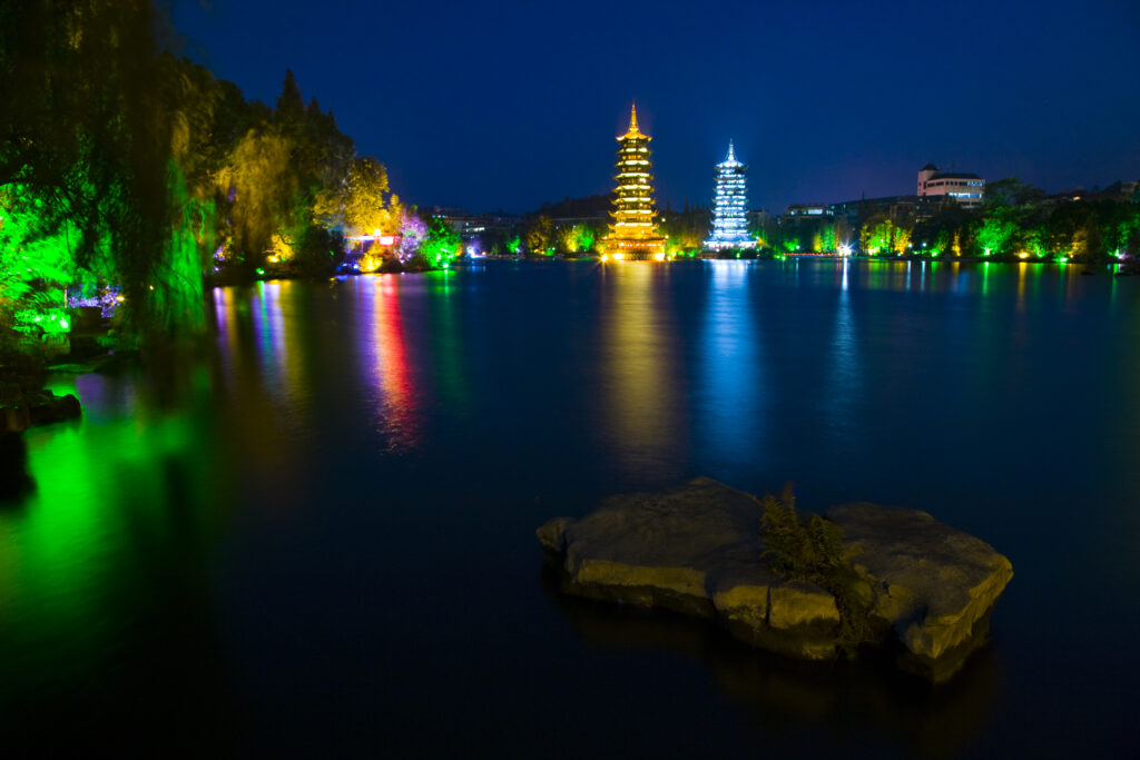 China, Guangxi Zhuang Autonomous Region, Guilin City. Illuminated Pagodas at dusk, located near Banyan Lake in downtown Guilin.