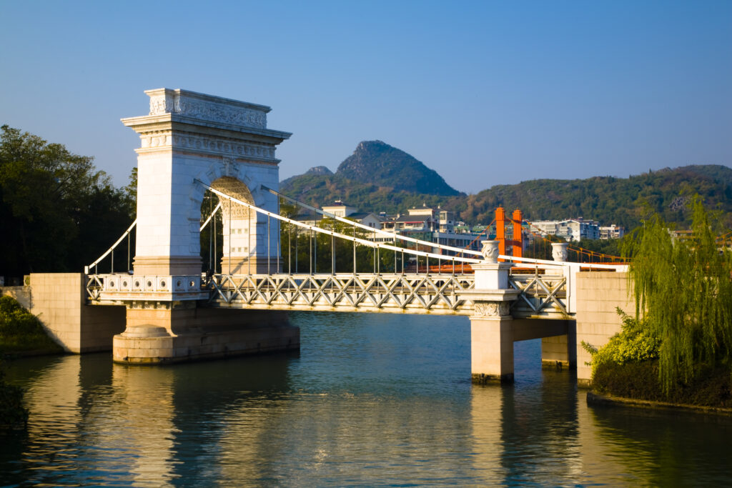 China, Guangxi Zhuang Autonomous Region, Guilin City. Bridge, waterfront and limestone Karst viewed from near downtown Guilin city.