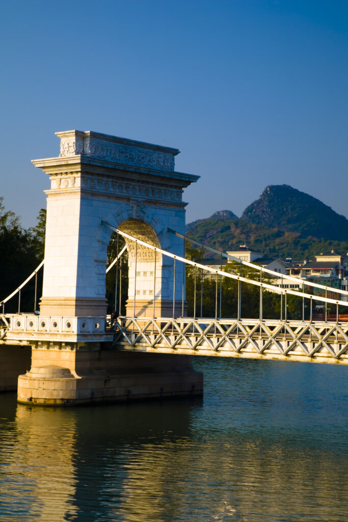 China, Guangxi Zhuang Autonomous Region, Guilin City. Bridge, waterfront and limestone Karst viewed from near downtown Guilin city.