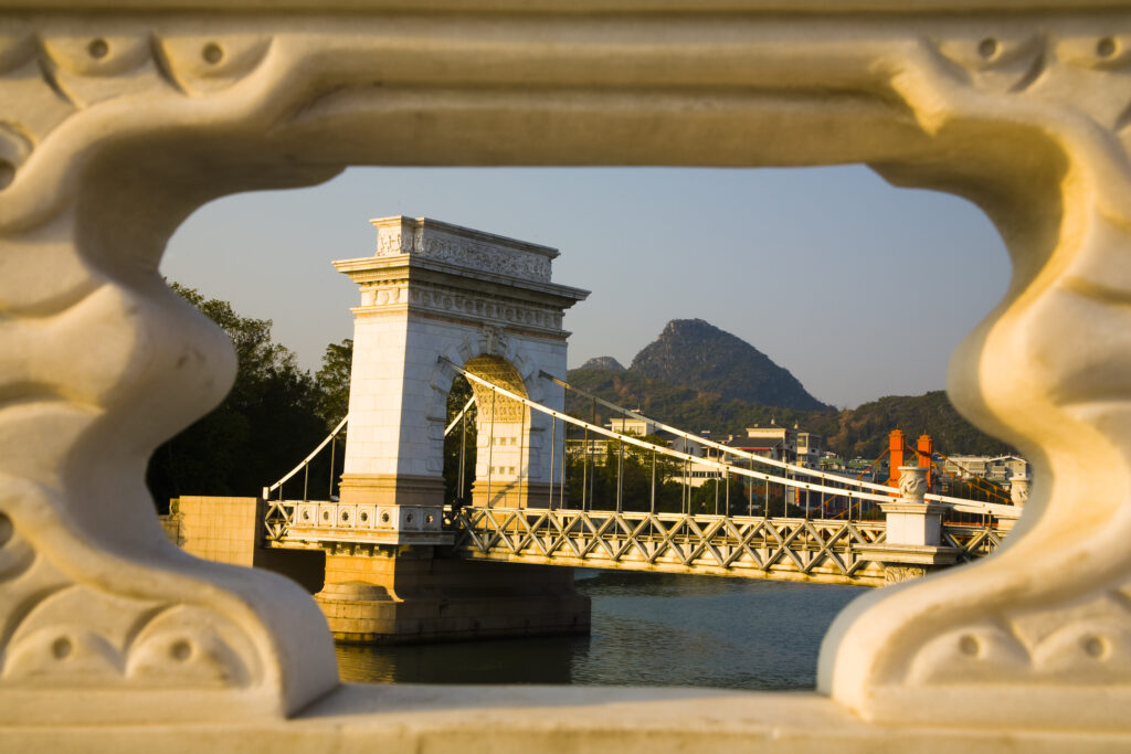 China, Guangxi Zhuang Autonomous Region, Guilin City. Bridge, waterfront and limestone Karst viewed from near downtown Guilin city.