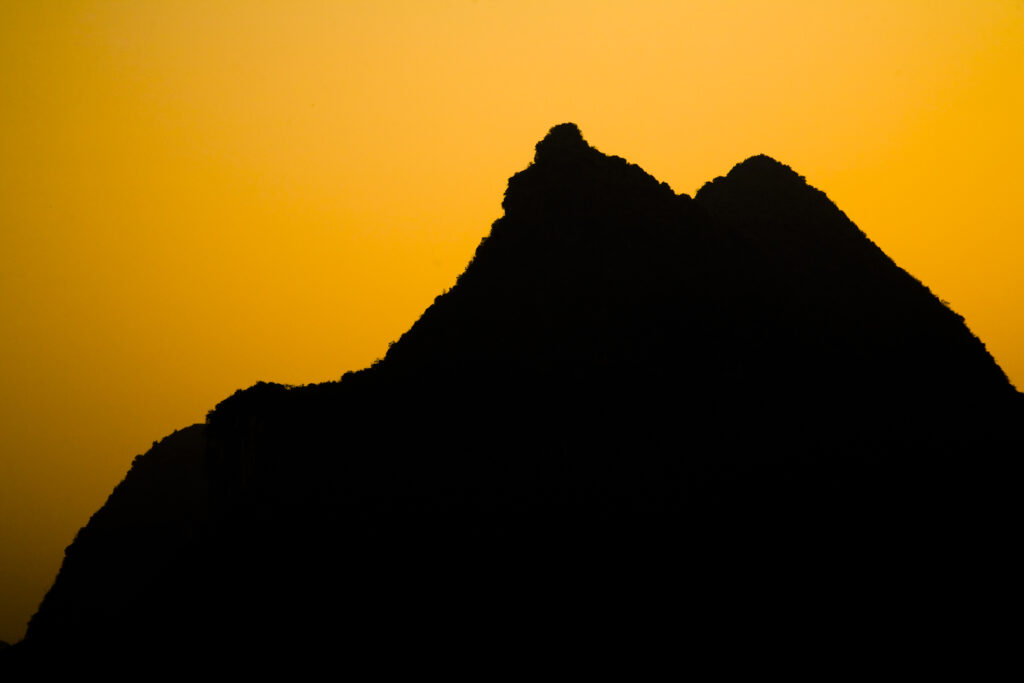 China, Guangxi Zhuang Autonomous Region, Yangshuo County. Sunset behind a karst peak near the town of Yangshuo.