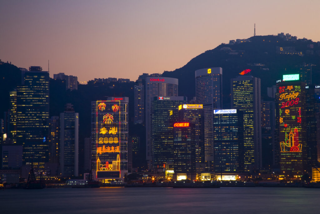 People's Republic of China, Hong Kong Special Administrative Region, Kowloon. The skyline of Kong Kong island viewed at dusk across Victoria Harbour from Kowloon.