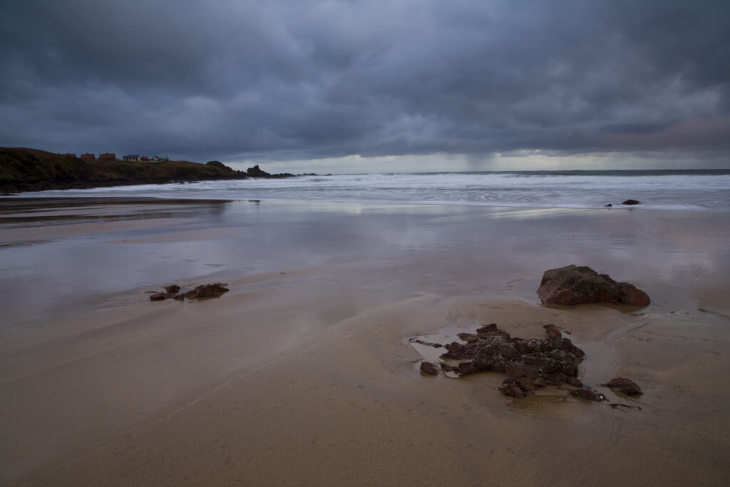 Scotland, Scottish Borders, Coldingham Bay. Storm clouds clear from above the sandy beach to be found at Coldingham Bay.