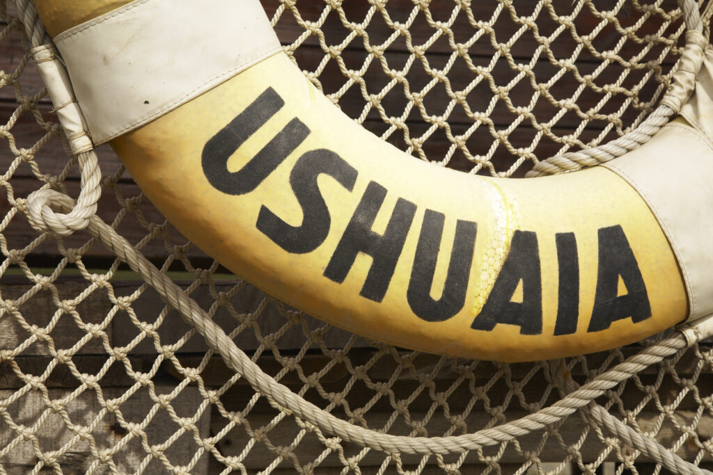 Argentina, Tierra Del Fuego, Ushuaia. Detail of lifering with Ushuaia caption against fishing net.