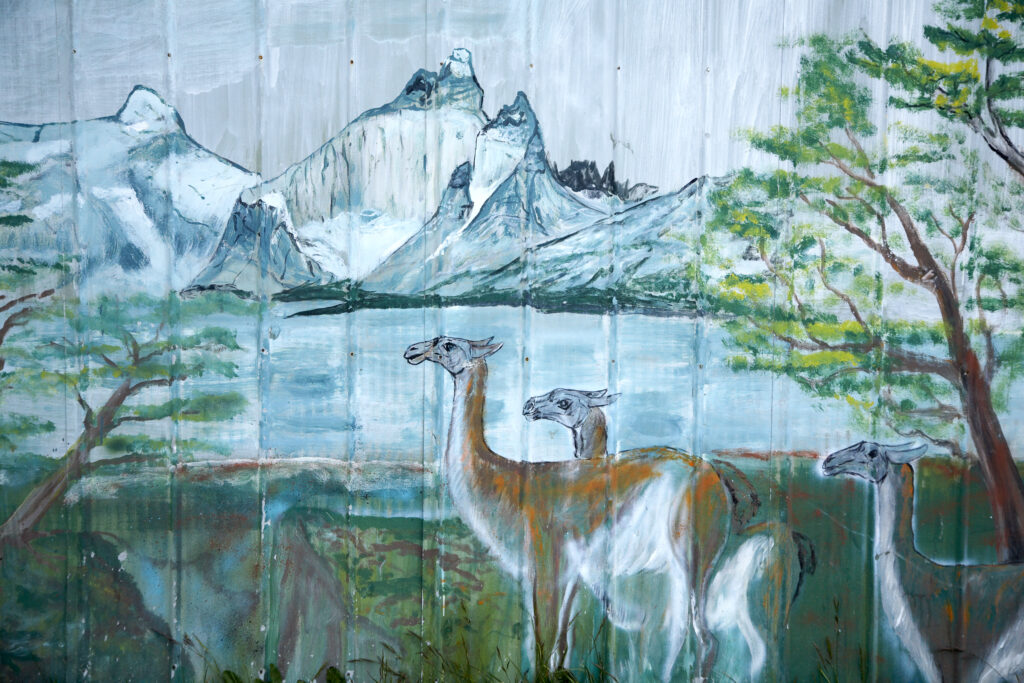 Chile, Southern Patagonia, Puerto Natales. Details of a painting on a fence in Puerto Natales featuring Patagonian scenery, flora and fauna.