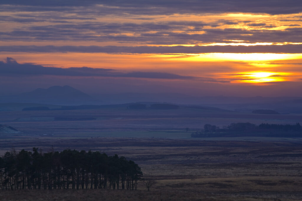 Scotland, Scottish Borders, Eildon Hills. Hazy sunset looking towards the Eildon Hills from near the town of Duns.