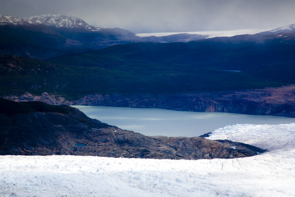 Chile, Southern Patagonia, Torres Del Paine National Park. A clearing storm reveals the Patagonian Ice Field and the Grey Glacier meeting the Lago Grey.
