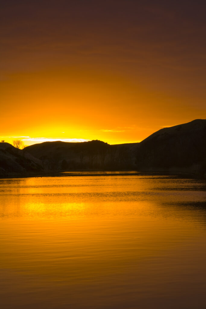 Scotland, Scottish Borders, Mire Loch. Sunrise reflected in Mire Loch, near the dramatic coastline of St Abbs head.