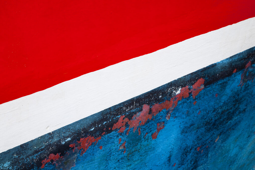 Scotland, Scottish Borders, St Abbs.. Weathered paint work on the hull of a fishing boat moored in the harbour of St Abbs.