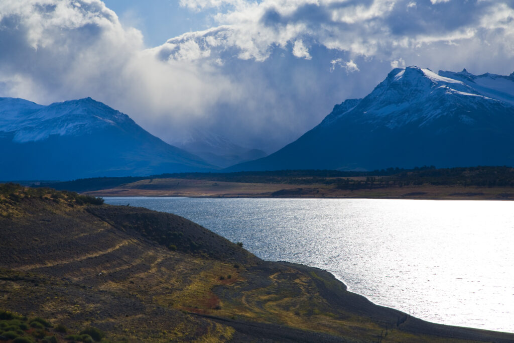 Argentina, Patagonia, Los Glaciares National Park. Storm clouds clear from above the Patagonian Mountains surrounding Brazo Rico in Lake Argentino.