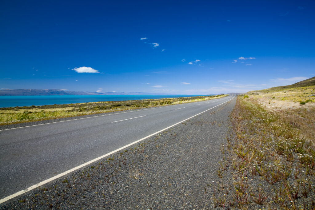 RF - Argentina, Patagonia, Santa Cruz. Highway road running alongside Lake Argentina through the open patagonian landscape.