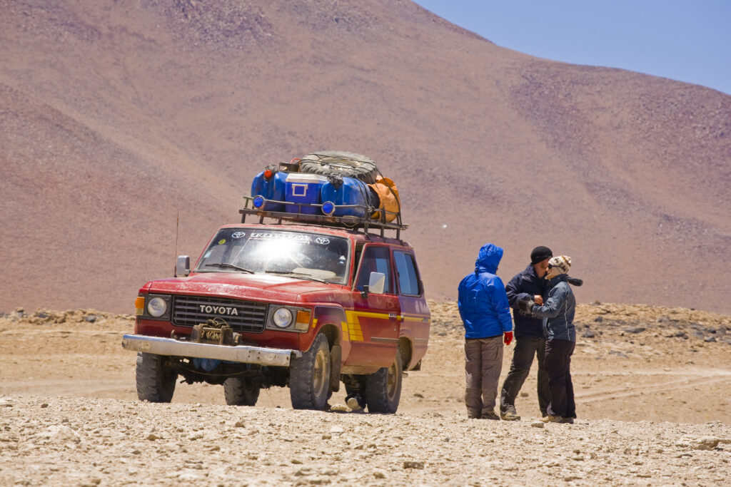 Bolivia, Southern Altiplano, Laguna Verde. Tourist and 4x4 jeep parked near Laguna Verde.