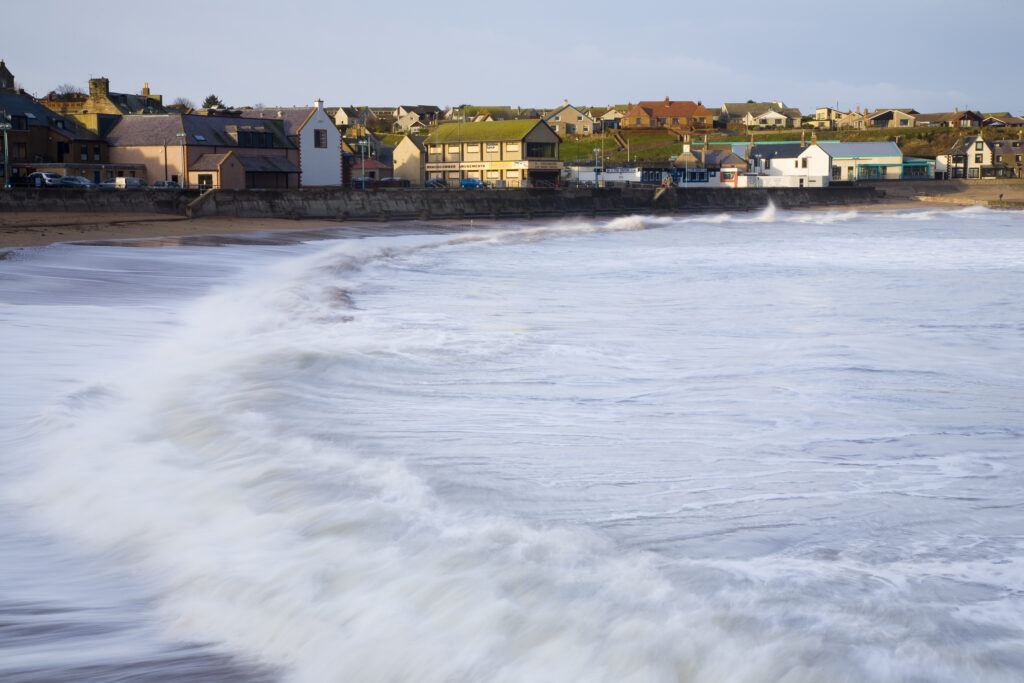 Scotland, Scottish Borders, Eyemouth. Gale force winds create large swells in the North Sea, demonstrating the importance of the sea wall defences in place at Eyemouth Bay.