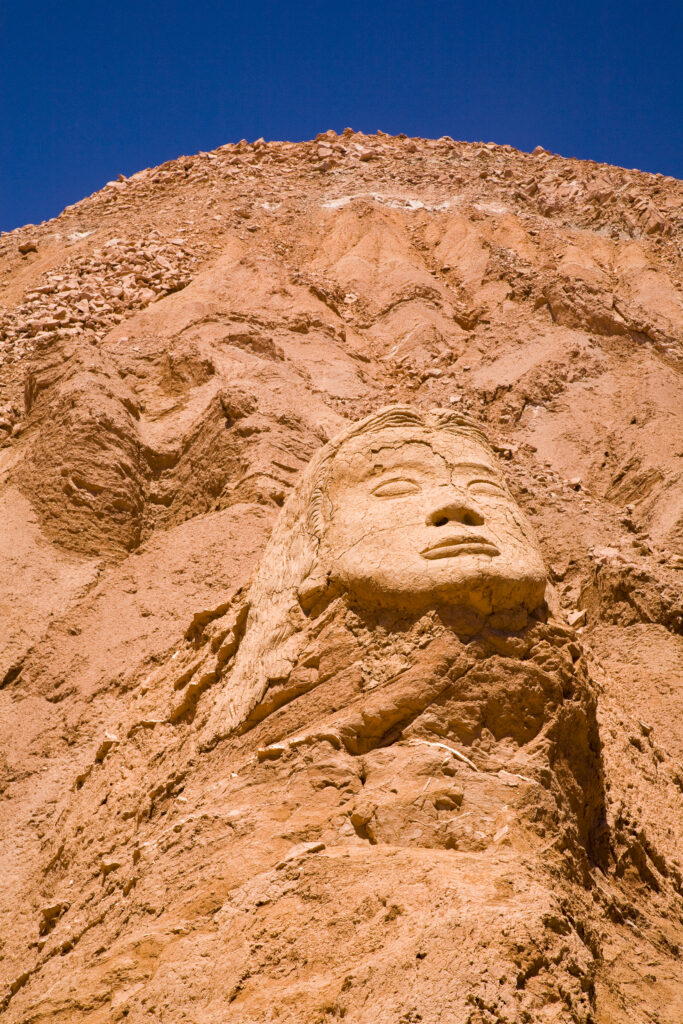 Chile, Atacama Desert, Plaza Quitor. Carved face in the stone wall of the Atacama Desert near the Plaza Quitor.
