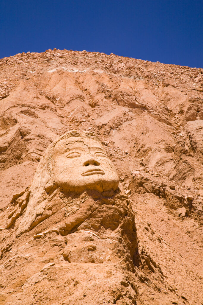Chile, Atacama Desert, Plaza Quitor. Carved face in the stone wall of the Atacama Desert near the Plaza Quitor.