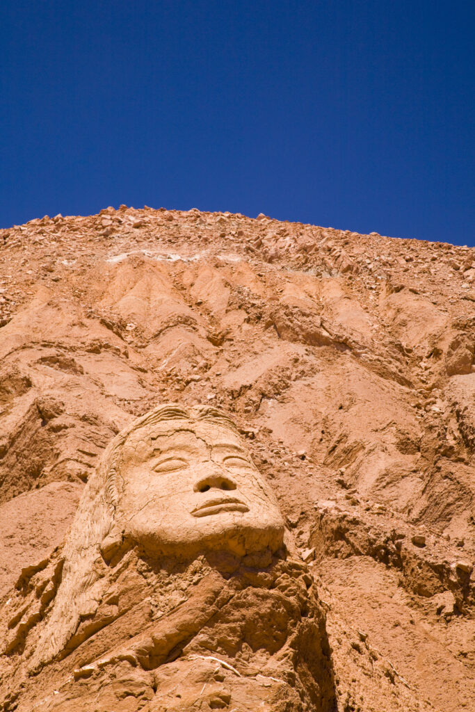 Chile, Atacama Desert, Plaza Quitor. Carved face in the stone wall of the Atacama Desert near the Plaza Quitor.