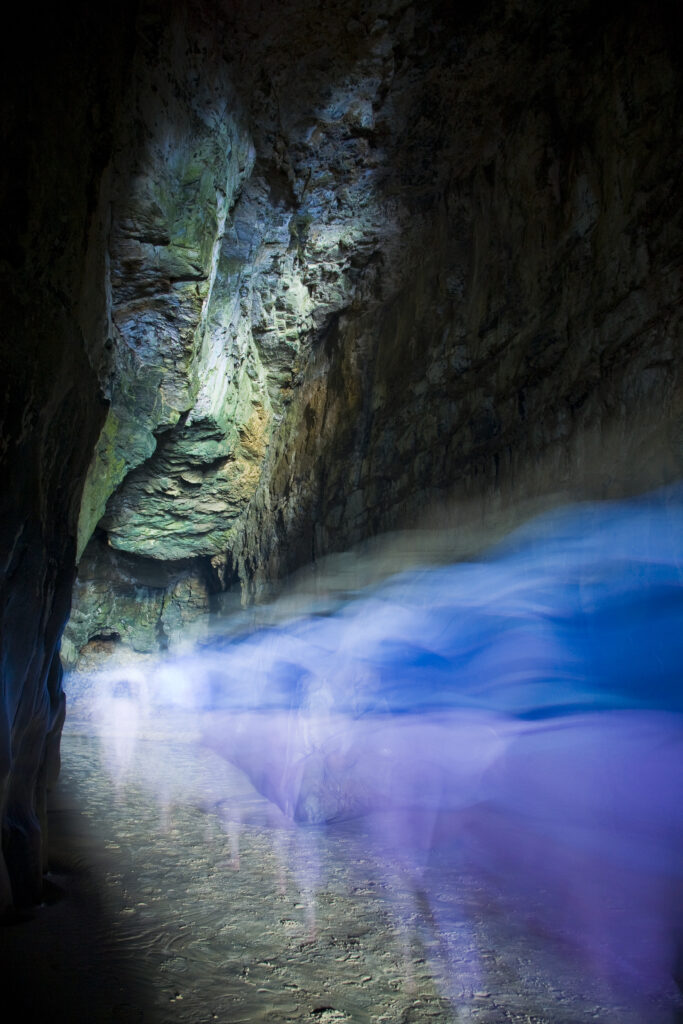 New Zealand, Southland, The Catlins. Abstract view of tourists exploring the Cathedral caves.
