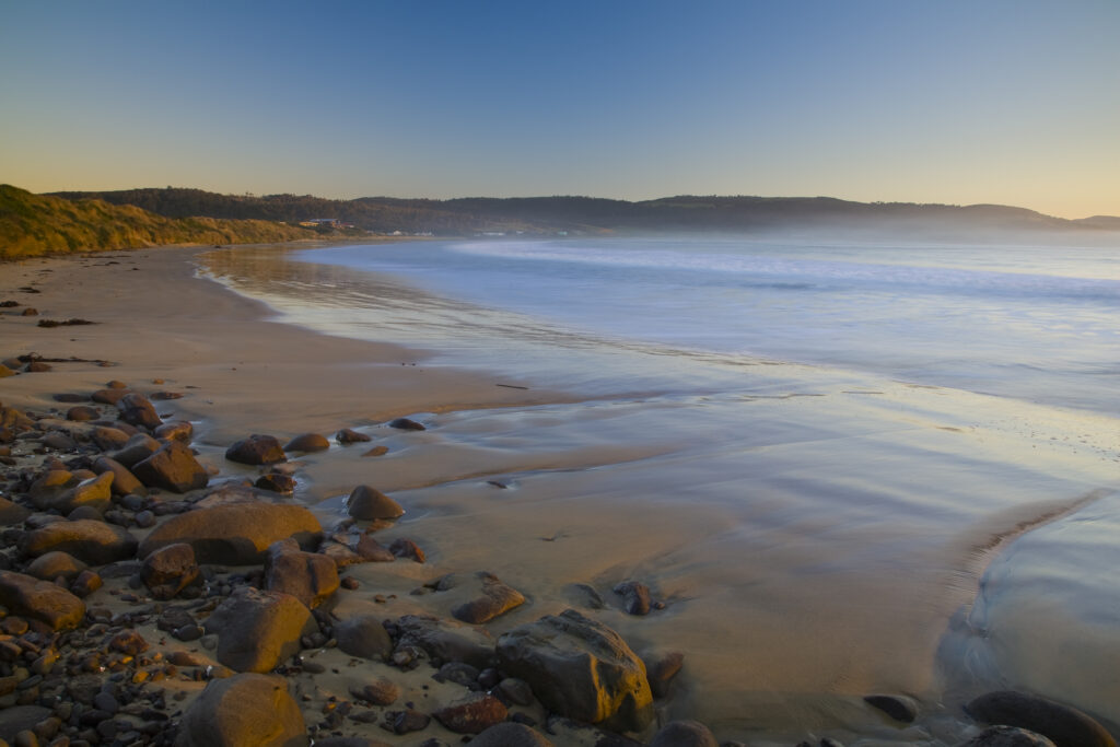 New Zealand, Southland, The Catlins. Looking across the golden sands of Porpoise Bay shortly after sunrise.